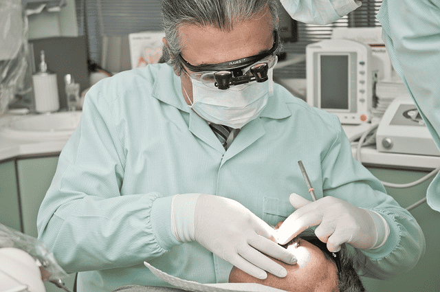 Dentist performing wisdom teeth removal with his patient